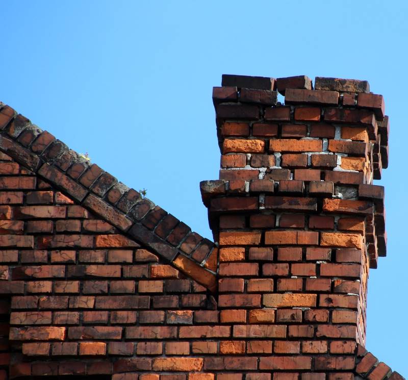 Damaged chimney on an Colleyville home showing cracks and missing mortar